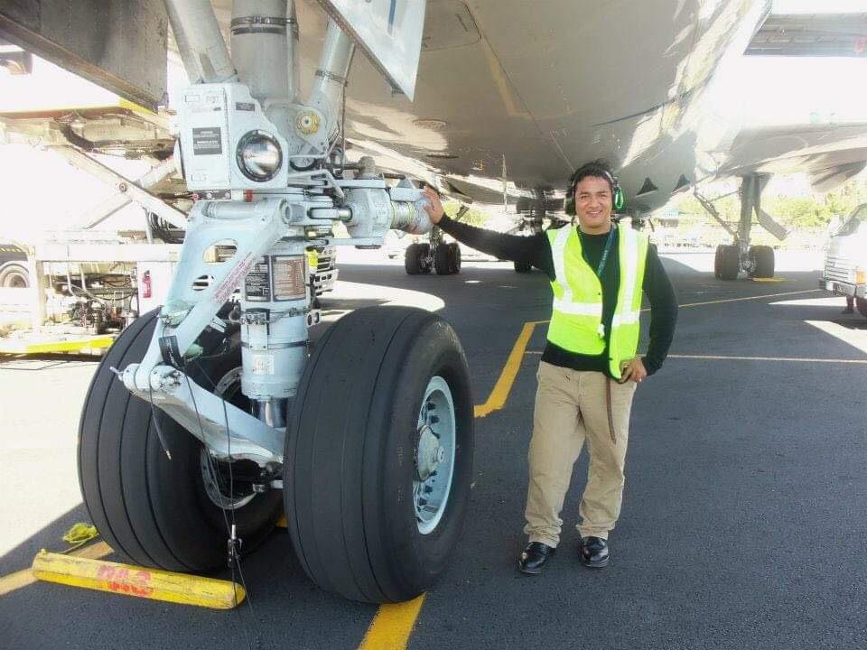 PAS engineer smiling next to big aircraft wheels