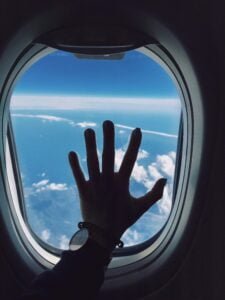 Hand on plane window